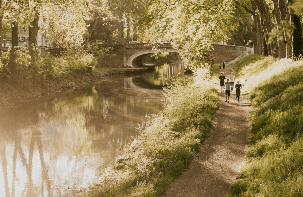 Groupe de coureurs le long d’un fleuve au lever du jour, symbole d’engagement collectif et de respect du vivant.